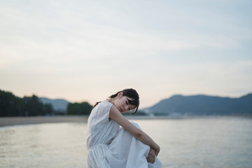 夕暮れの海の女性