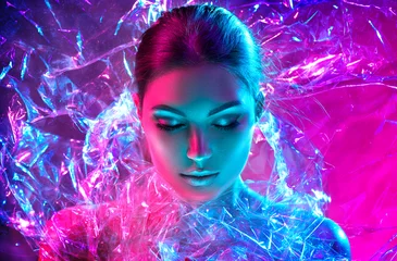 Foto op Canvas Mannequin vrouw in kleurrijke felle neonlichten poseren in studio door transparante film. Portret van mooi sexy meisje in UV. Art design kleurrijke make-up © Subbotina Anna