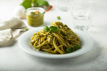 Pasta with pesto sauce and fresh basil leaves