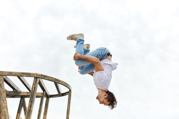 man holding legs performing a stunt upside down. full length side view photo. dangerous kid of...