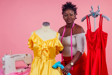african american tailor dressmaker holding vapor device hot steam generator for silk red and yellow...