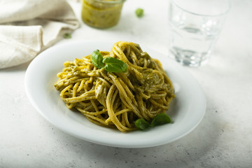 Pasta with pesto sauce and fresh basil leaves