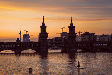 Beautiful sunset view at the Oberbaum Bridge in Berlin with the famous Television Tower in the back