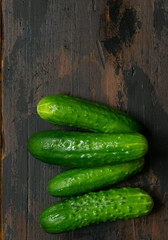 Fresh green cucumbers on a old wooden table. Organic food. Top view.