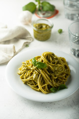 Pasta with pesto sauce and fresh basil leaves