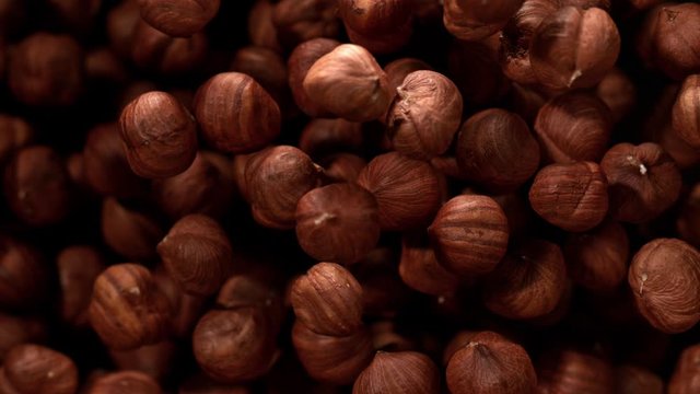 Super Slow Motion Shot of Hazelnuts Flies After Being Exploded against Black Background, 1000fps
