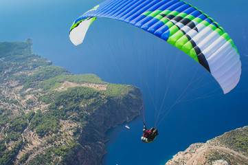 Dream to fly. Paraglider flying. Top view. Blue sky and sea.