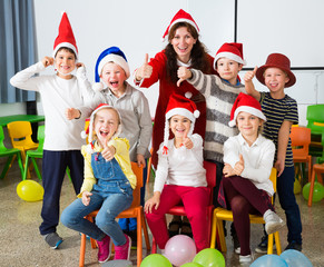 Pupils with teacher in Santa hats giving thumbs up