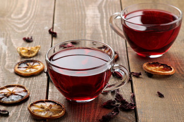 Hibiscus red tea in glass cups on a brown wooden table. a warming drink. autumn or winter drink