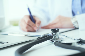 Mid section of female doctor writes prescription to patient at worktable. Panacea and life save, prescribing treatment.