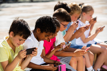 Children are playing on smartphone in the playground