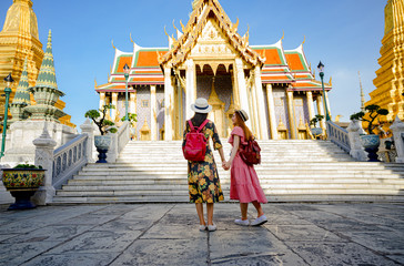 young tourist women walking through the palace temple in Bangkok of Thailand, Emerald Buddha...