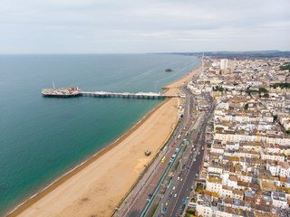 Fototapeta na wymiar Aerial photo of the famous Brighton Pier and ocean located in the south coast of England UK that is part of the City of Brighton and Hove, taken on a bright sunny day showing the fairground rides.