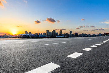 Asphalt road ground and city skyline at sunset in Shanghai,China.