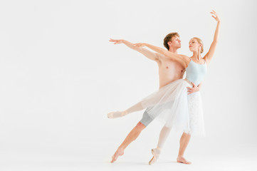 Obraz premium Young couple of modern ballet dancers posing over white studio background