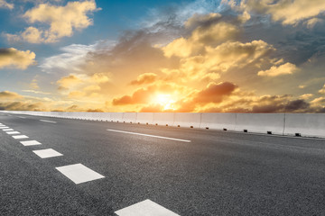 Fototapeta premium Empty asphalt highway and beautiful sky clouds at sunset