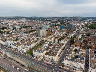 Fototapeta na wymiar Aerial photo of the Brighton and Hove town centre showing hotels, guest houses, local businesses and the roads and streets of the town centre, taken on a bright sunny day with a drone over the town.
