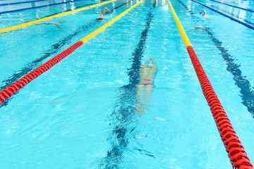 A teenage athlete is swimming crowl. Without face, selective focus.