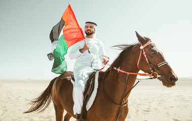 Arabian man with traditional clothes riding his horse