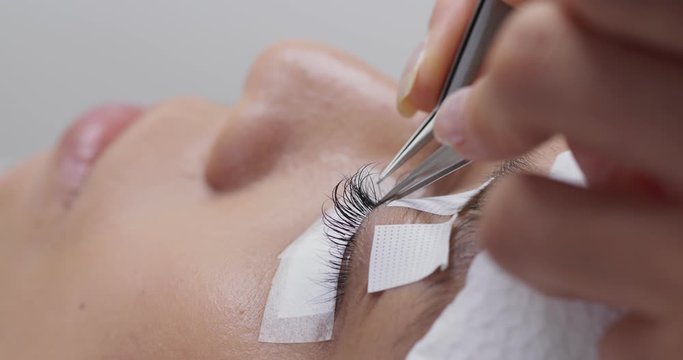 Beautiful young woman with eyelash extension in salon
