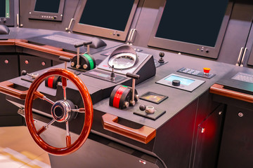 Captains bridge. Boat control panel with steering wheel on the captain bridge. Wheelhouse on a motor yacht. The place of the captain of the ship. Electronics on a modern ship. Boat management courses. © Grispb