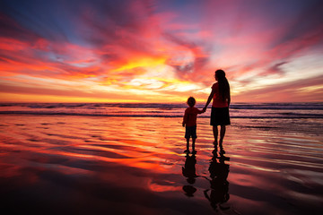 mother and son having fun at sunset on the beach