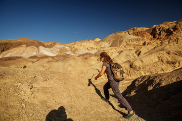 A hiker in the Artist`s Palette landmark place in Death Valley National Park, Geology, sand.