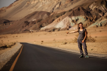 Obraz premium hitchhiker woman walking on a road in USA