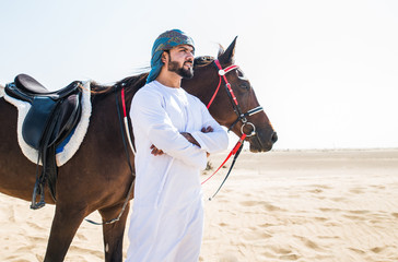 Arabian man with traditional clothes riding his horse