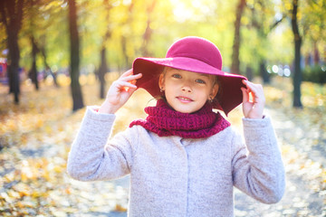 Girl in classic coat and hat in autumn park. Autumn season, fashion, childhood.