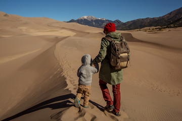 A man with his son are hiking in desert