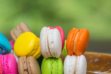 Colorful Macaroons in dish on wooden table