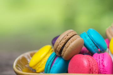 Colorful Macaroons in dish on wooden table