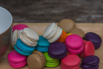 Colorful Macaroons in dish on wooden table