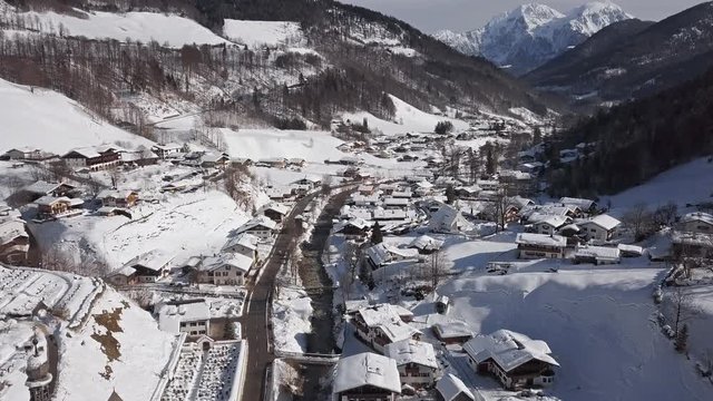 Winter flight over Ramsau town and famous Parish church St. Sebastian, Berchtesgaden, Bavarian Alps, Germany