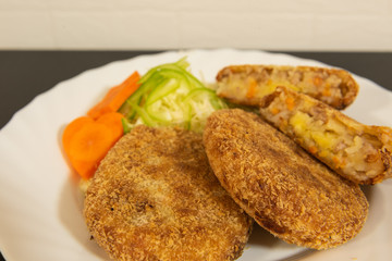 Homemade vegetable poak croquettes with salad, minced poak, potato and carrot in the croquettes. 