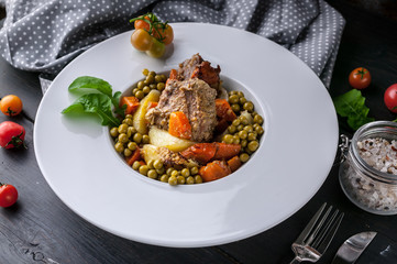 Potatoes, carrots, green peas and turkey meat on a white plate. Baked meat with vegetables
