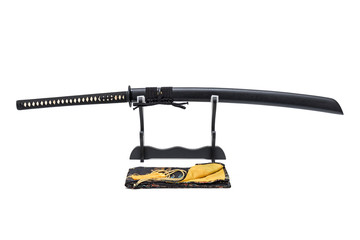 Nagamaki - Long grip Japanese sword with black scabbard  on wooden stand and silk bag in the front isolated in white background.