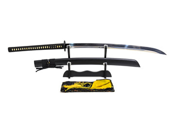 Nagamaki - Long grip Japanese sword with black scabbard  on wooden stand and silk bag in the front isolated in white background.