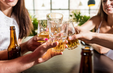 Cheerful friends in the pub. Drinking beer, talking, having fun.