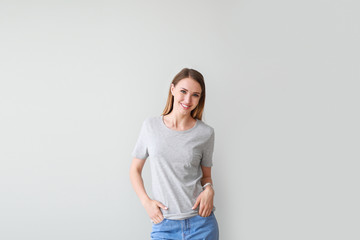 Woman in stylish t-shirt on light background