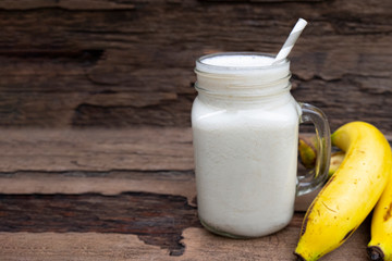 Banana fresh cocktail vanilla smoothies juice white fruit beverage healthy the taste yummy In glass for milkshake on wooden background.