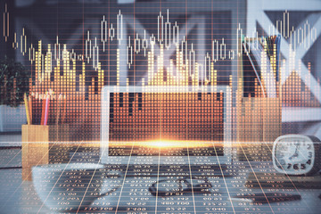 Double exposure of graph and financial info and work space with computer background. Concept of international online trading.