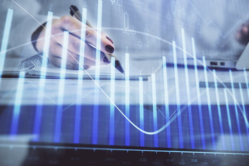 Double exposure of woman's hands making notes with forex graph hologram. Concept technical analysis.