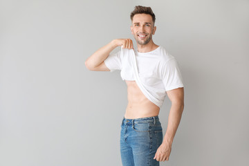 Handsome muscular man on light background. Weight loss concept