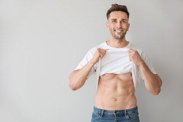 Handsome muscular man on light background. Weight loss concept