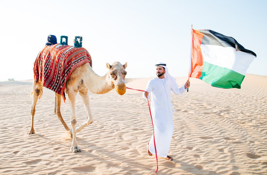 Arabian man with traditional clothes riding his camel