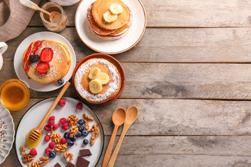 Fototapeta na wymiar Composition with tasty pancakes on wooden background