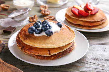 Tasty pancakes with berries on wooden table