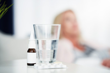 Adult woman feeling unewll and taking tablets at home